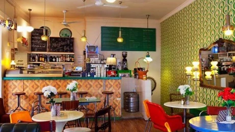 Concorregut taulell de cafeteria moderna amb baristes treballant i clients demanant